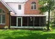 Brick house with screened back porch and green lawn