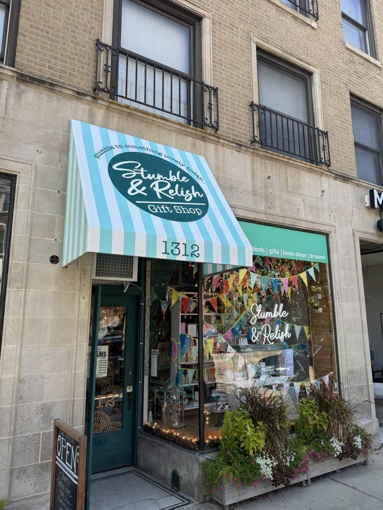 Storefront with teal striped awning and window display, likely a boutique shop on a city street.