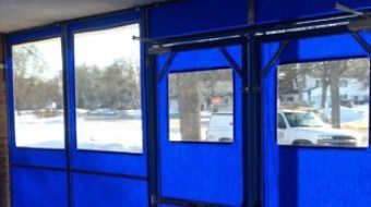 Blue-tinted bus shelter windows with snowy street view outside