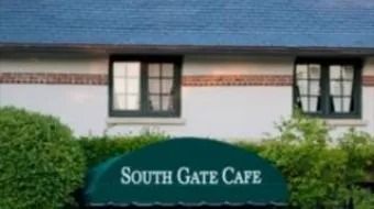 South Gate Cafe sign on a white building with windows and blue awning
