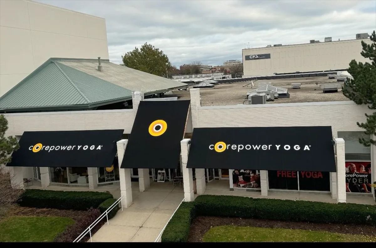Empower Yoga storefront with black awnings and yellow logo, seen from above
