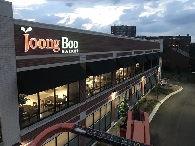 Joong Boo Market storefront at dusk with lit windows and a cloudy sky