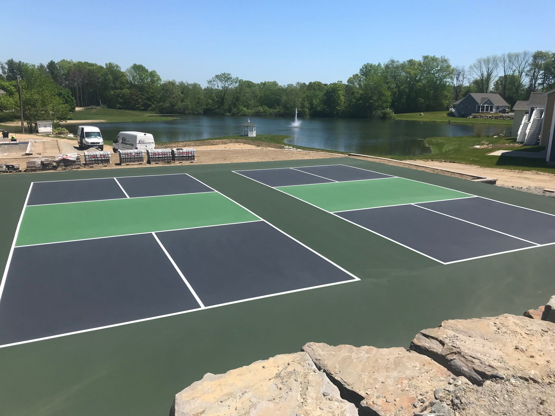 a tennis court with a lake in the background