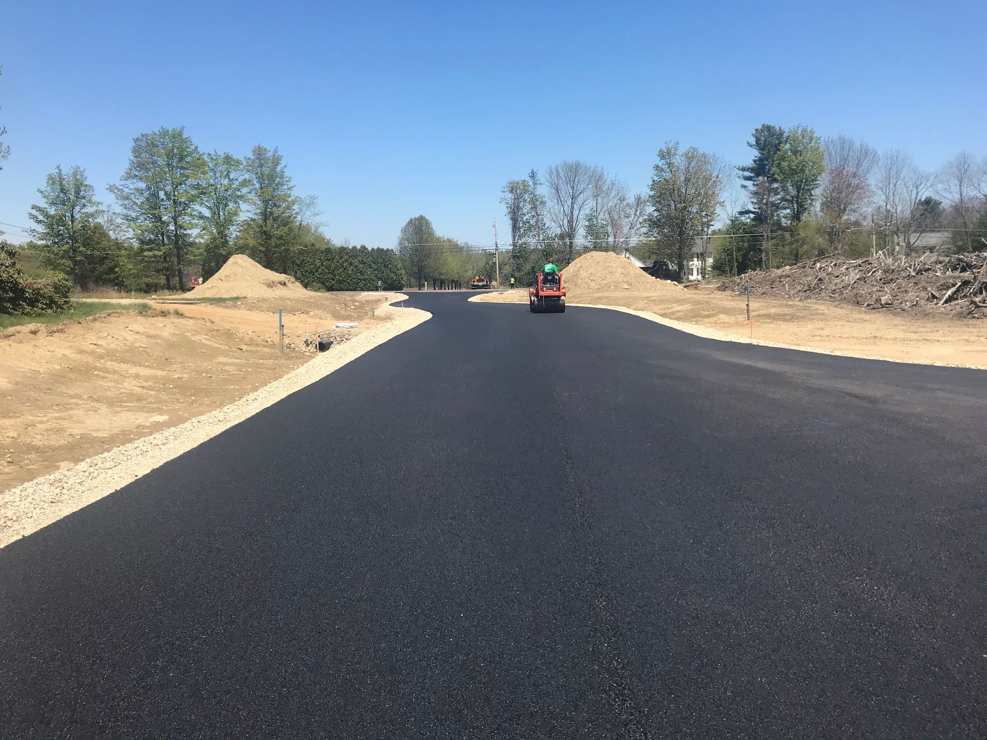 a tractor is driving down a road in a residential area