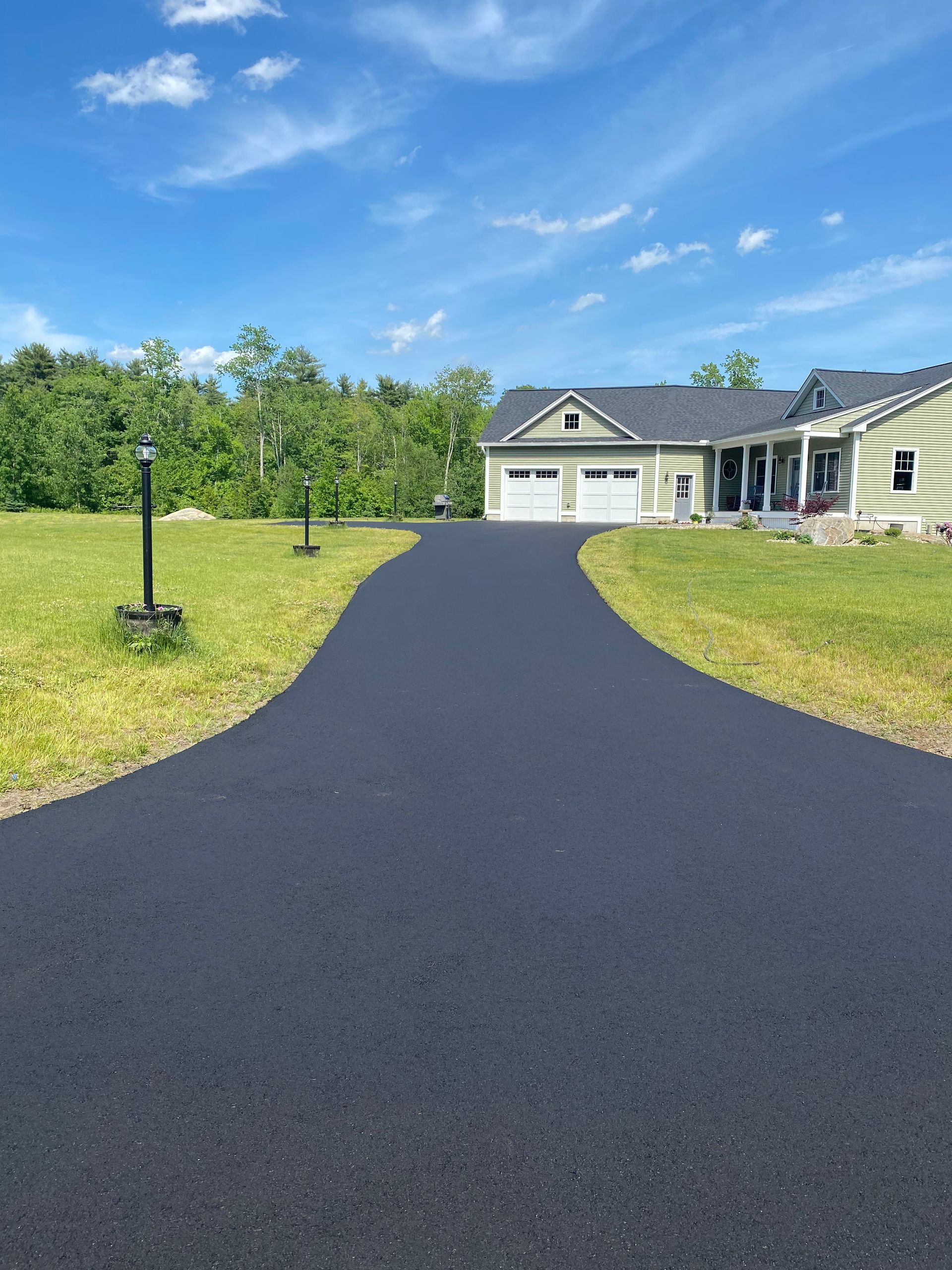 a driveway leading to a house on a sunny day