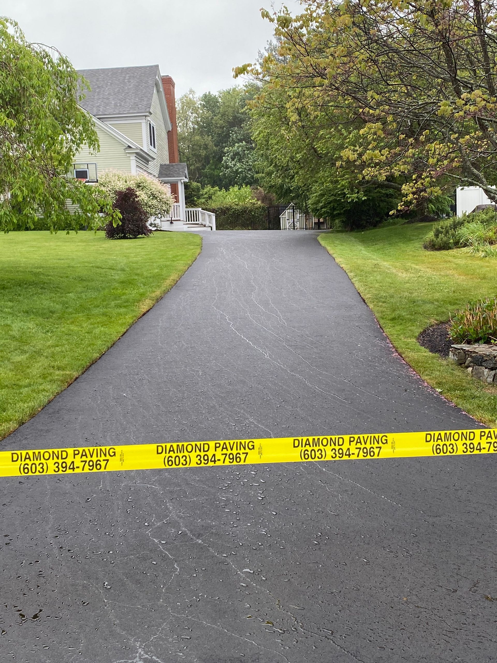a driveway leading to a house with yellow tape on it
