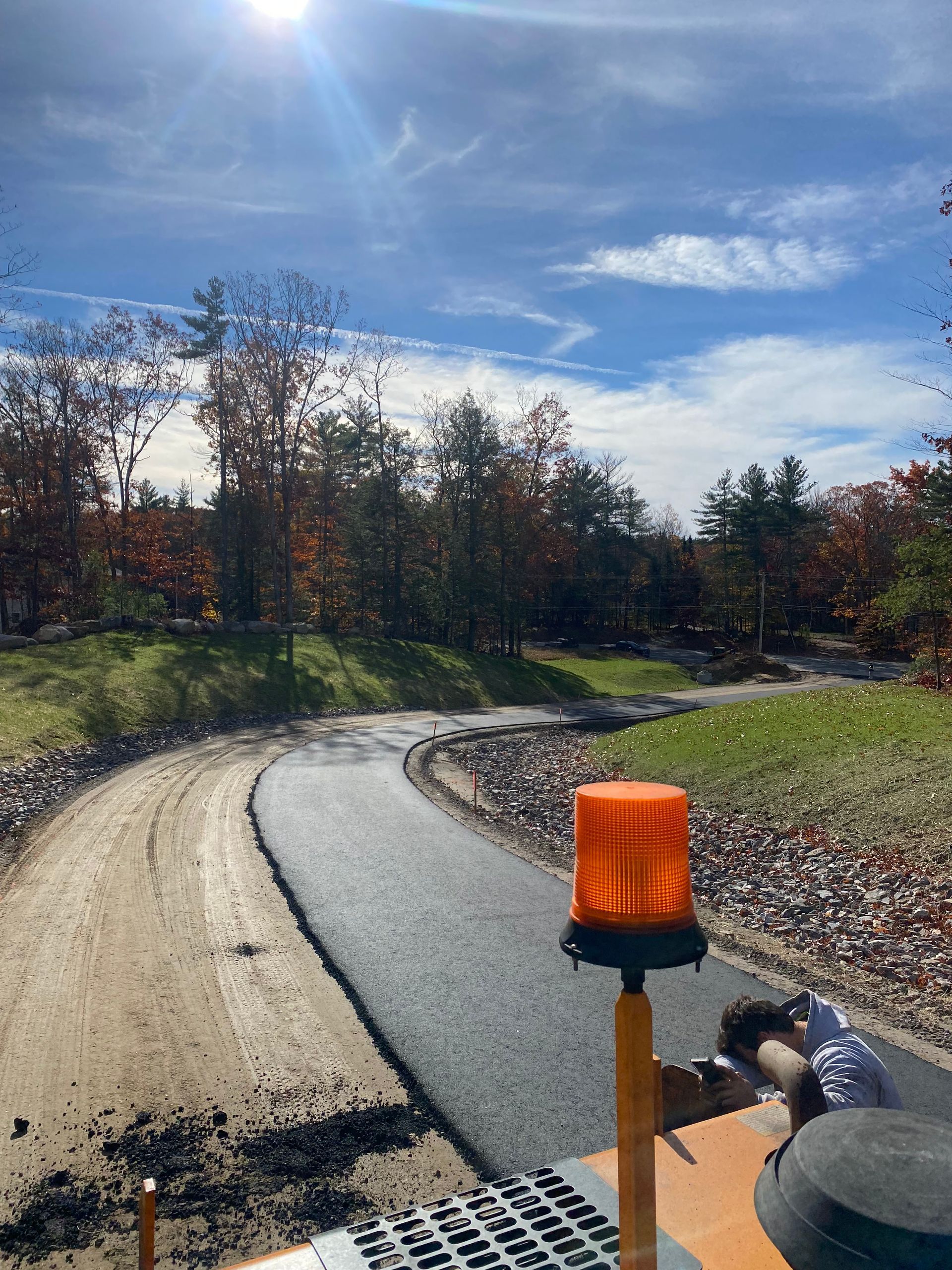 a person is driving a tractor down a dirt road