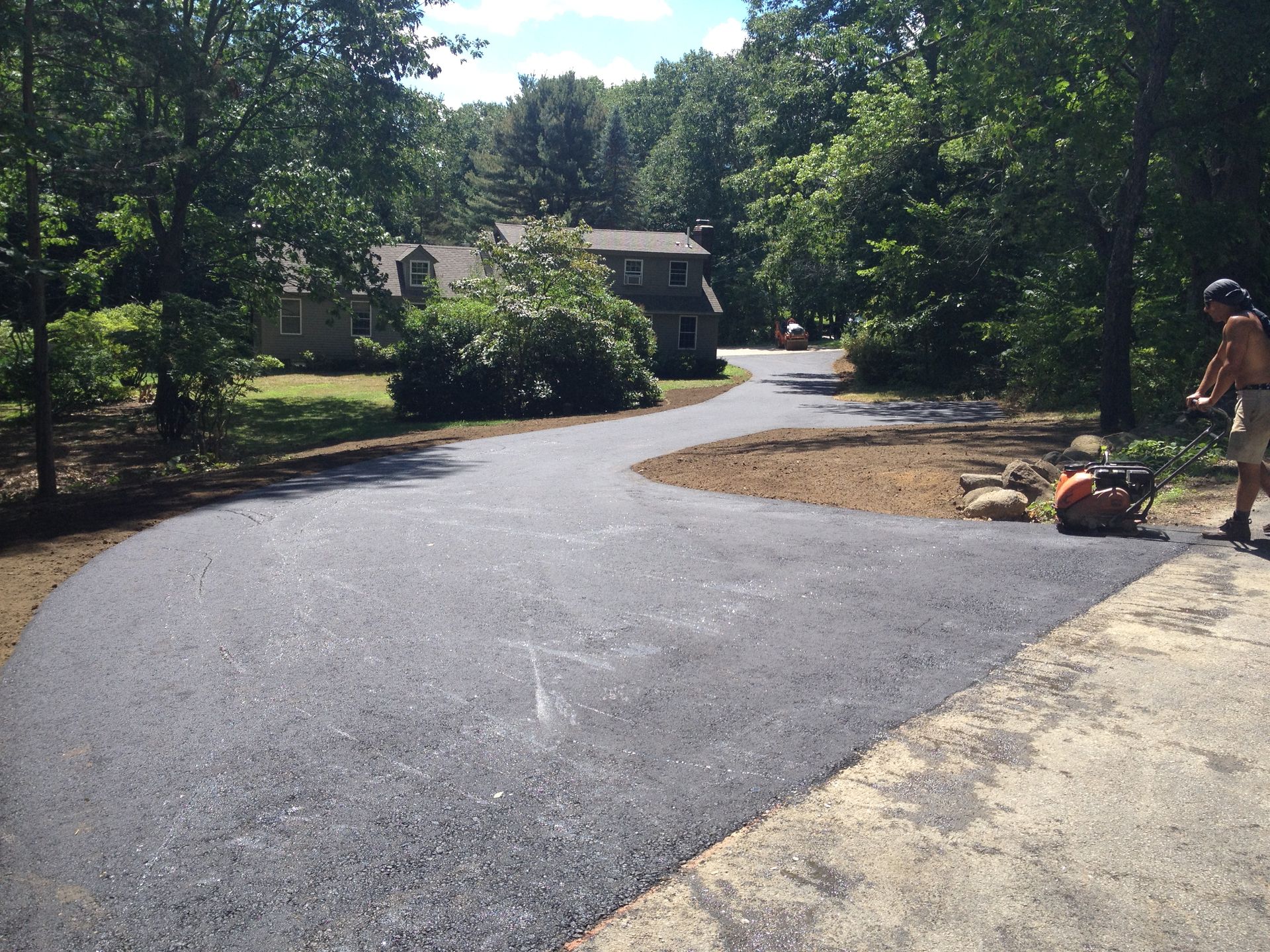 a man is standing on the side of a road in front of a house