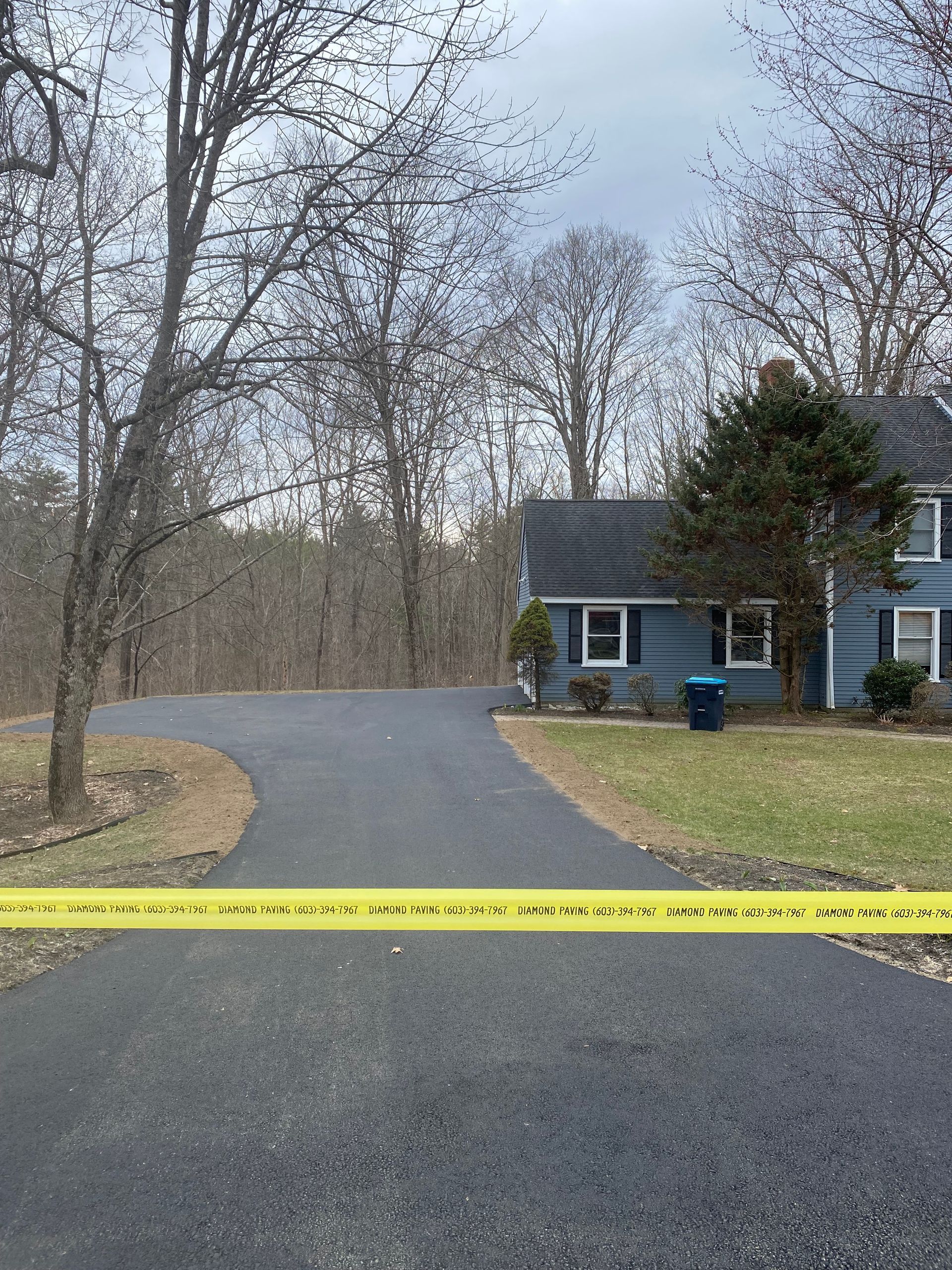 a blue house surrounded by trees and a yellow tape