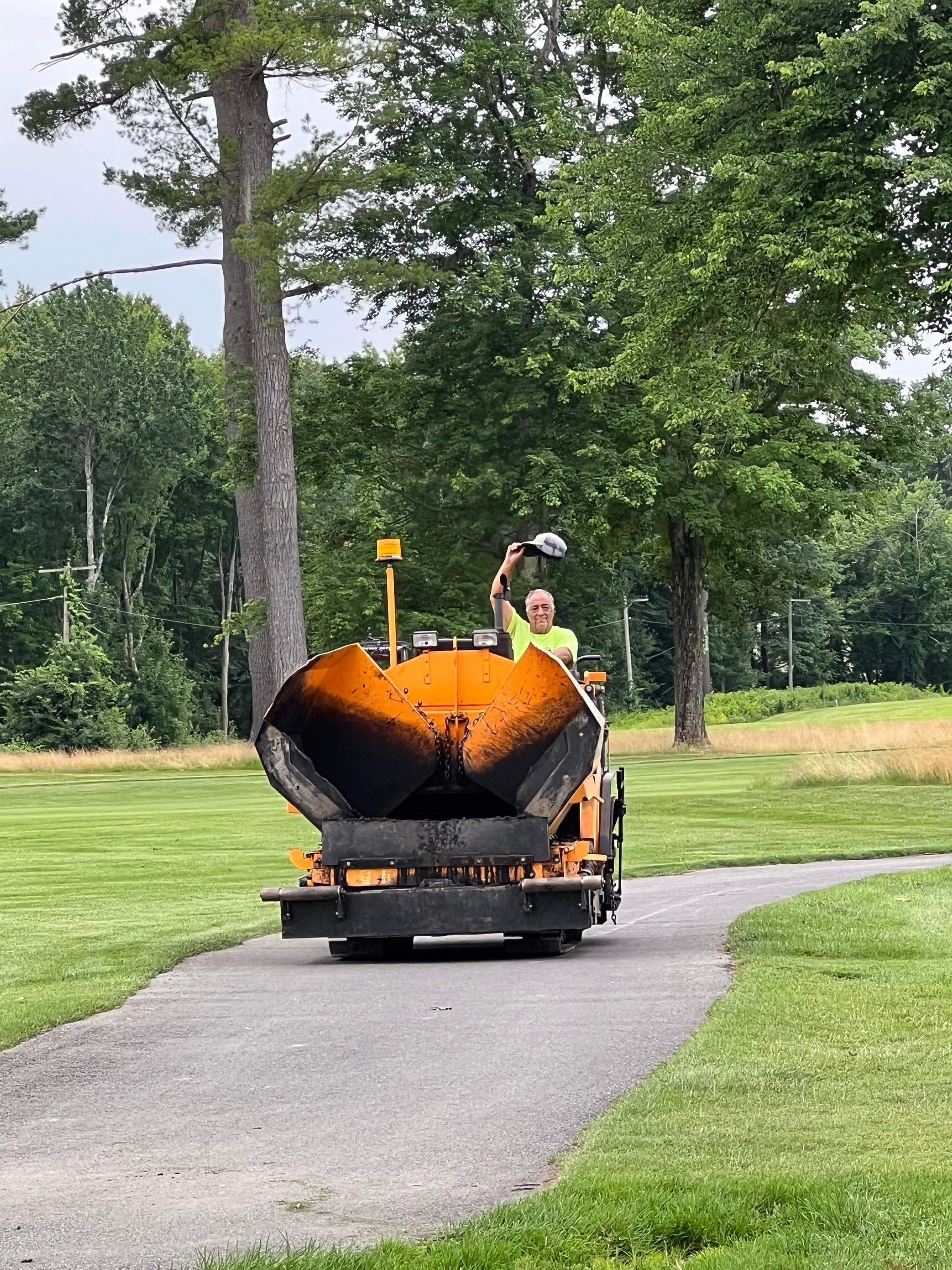 a man is driving a plow down a path in a park