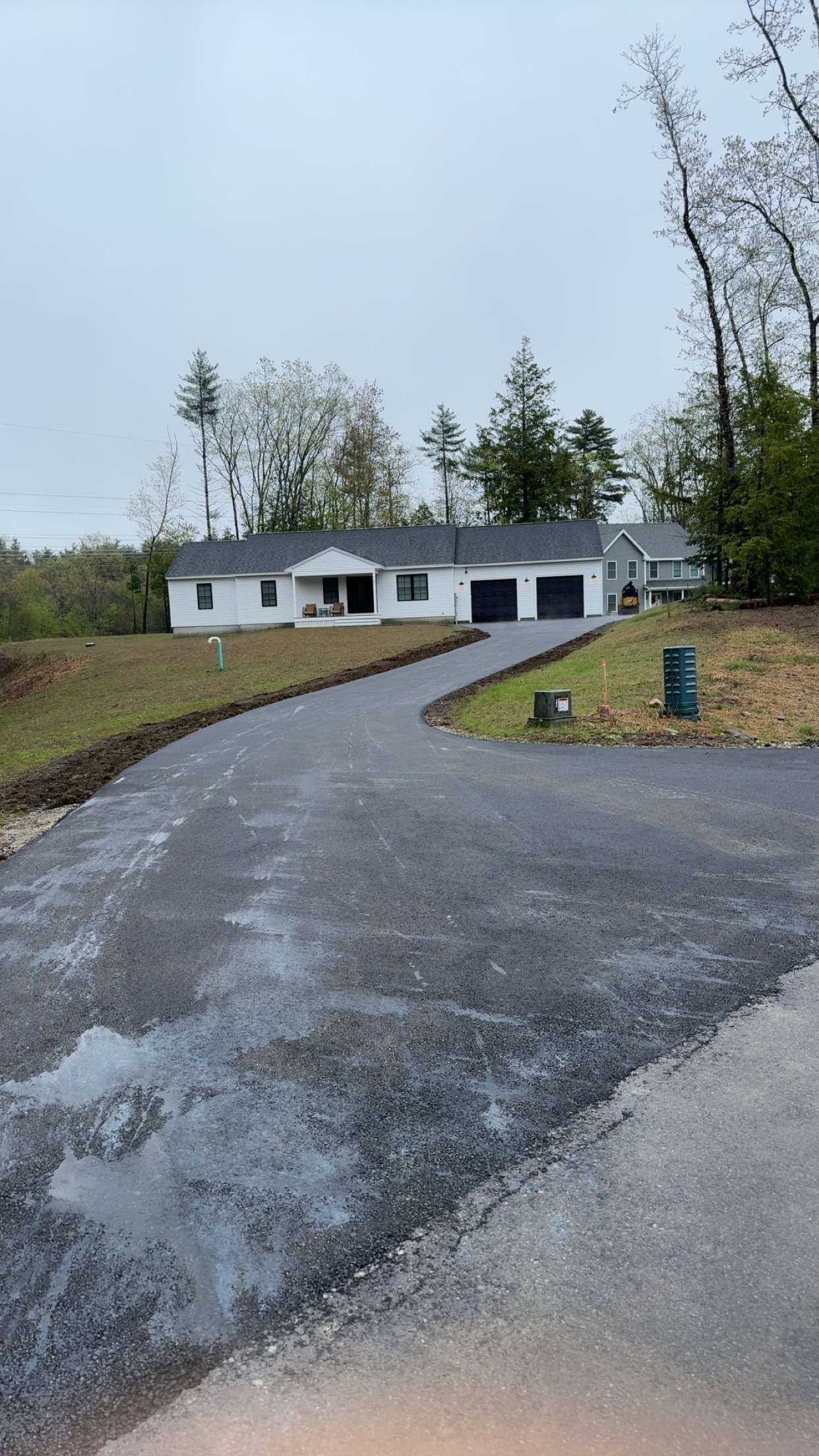 A house is sitting on top of a hill next to a road.