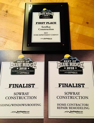 Three blue ridge awards are sitting on a wooden table