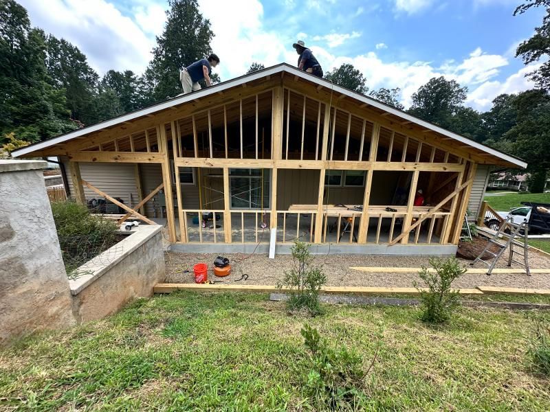 Two men are working on the roof of a house under construction.