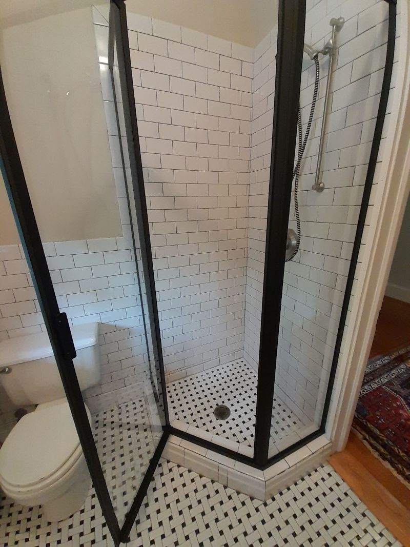 A bathroom with a shower stall and a toilet