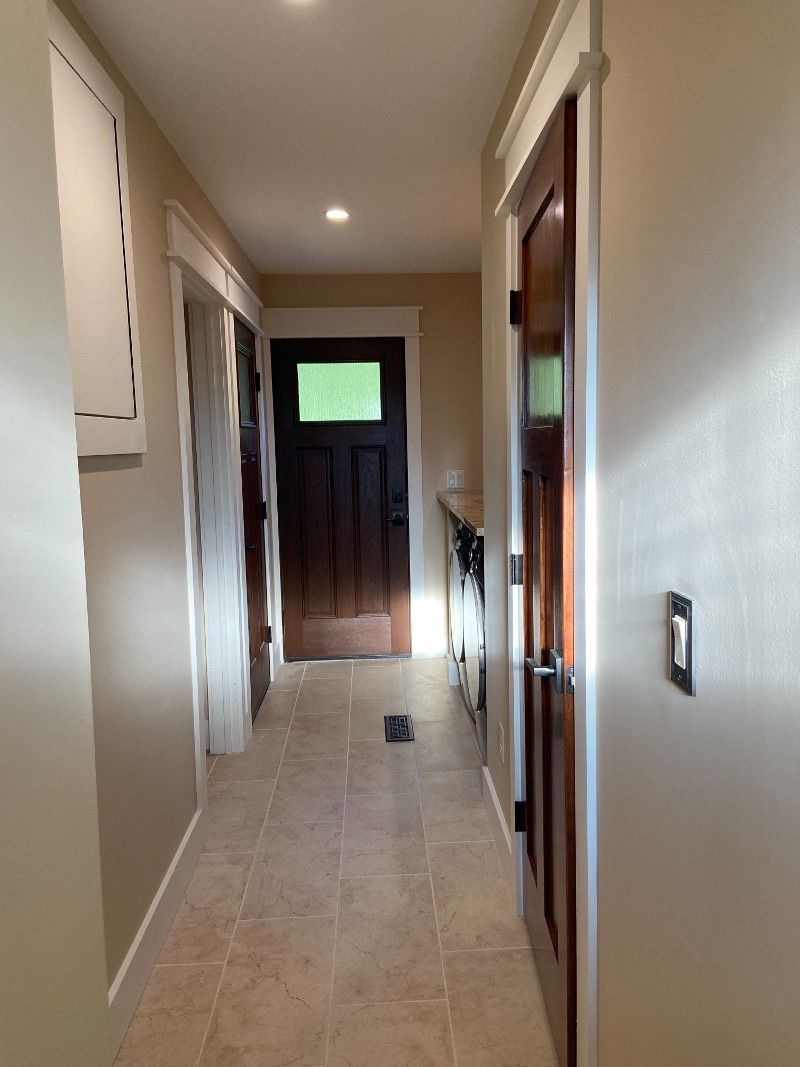 A hallway in a house with a door and a window.
