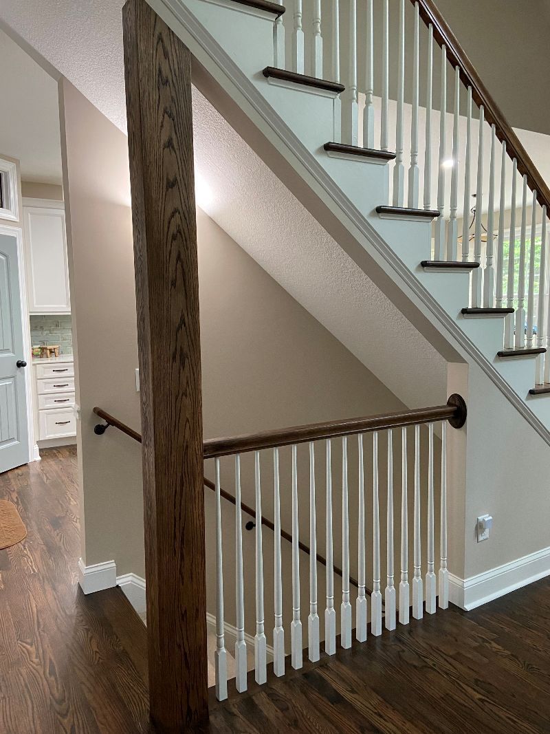 A staircase with a wooden railing and a wooden post in a house.