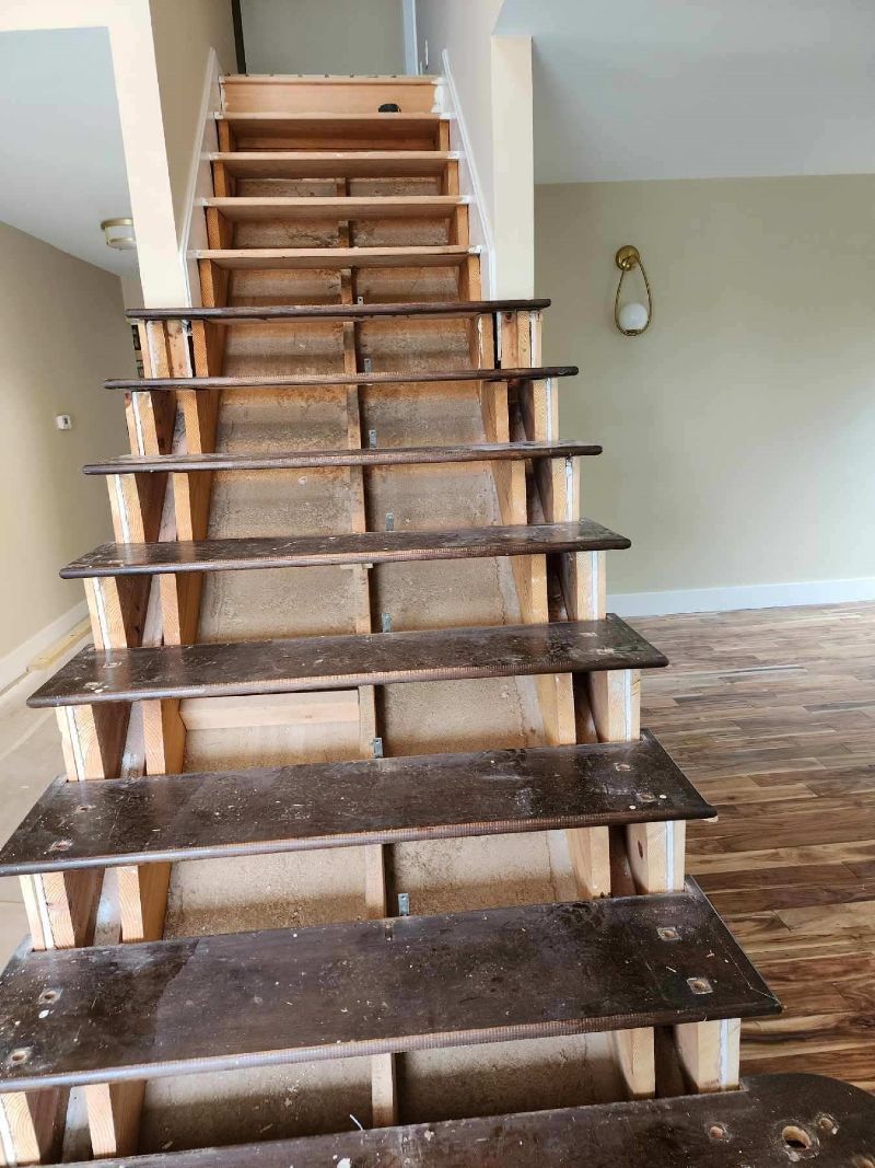 A wooden staircase is being built in an empty room.
