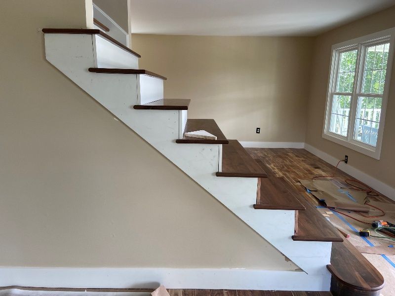 A white staircase with wooden steps in a room