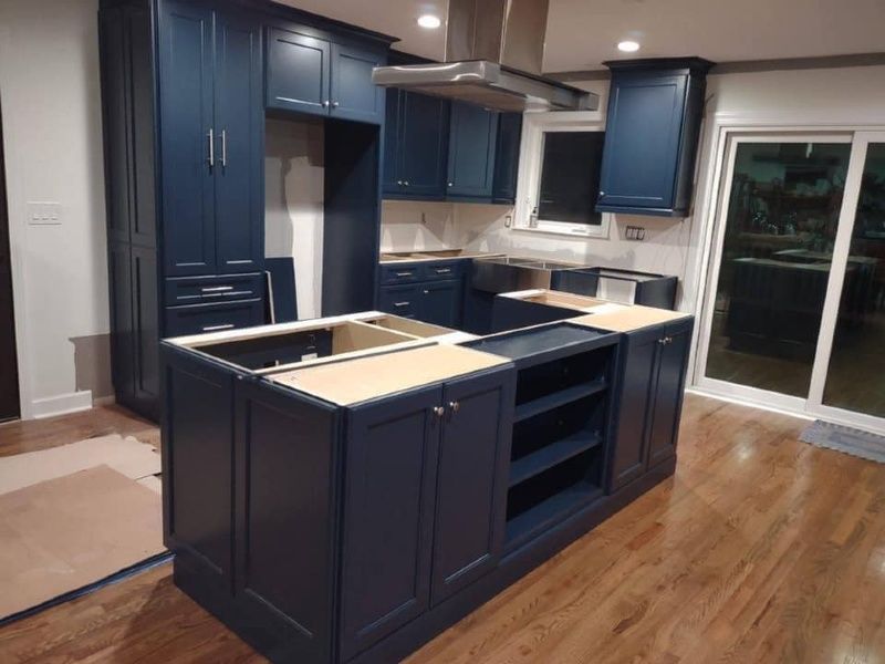 A kitchen with blue cabinets and stainless steel appliances
