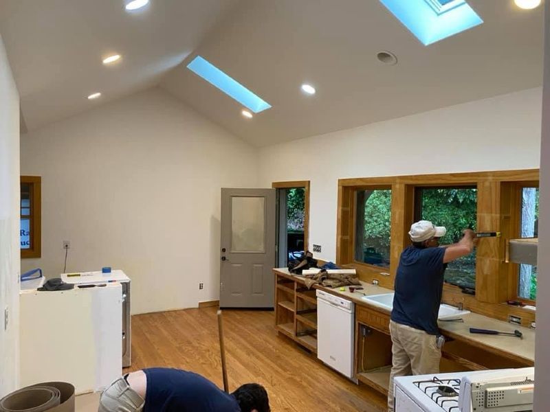 Two men are working in a kitchen under a skylight.