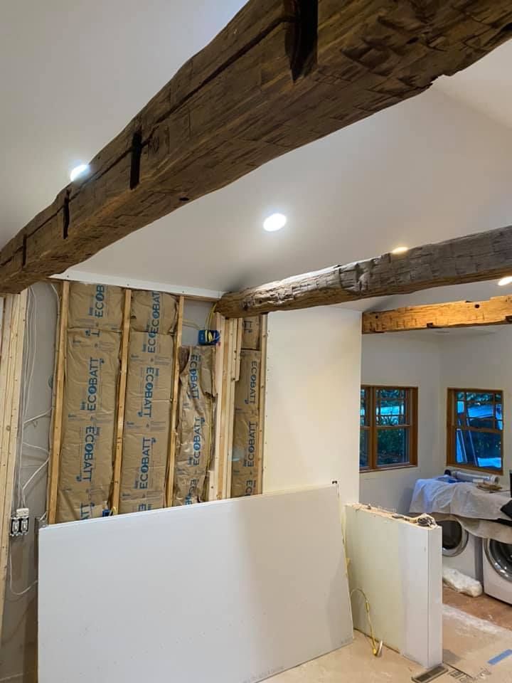 A room with wooden beams and a white wall.