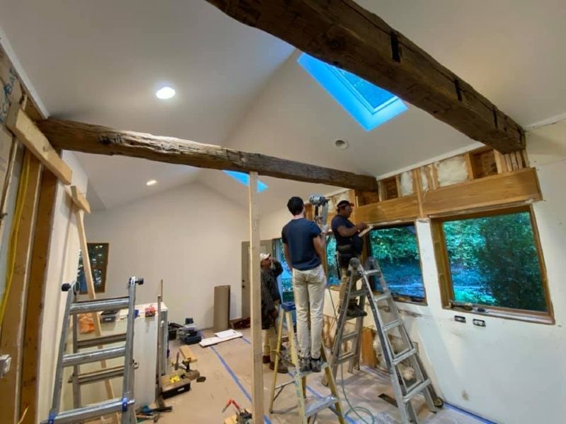 A group of people are standing on ladders in a room.