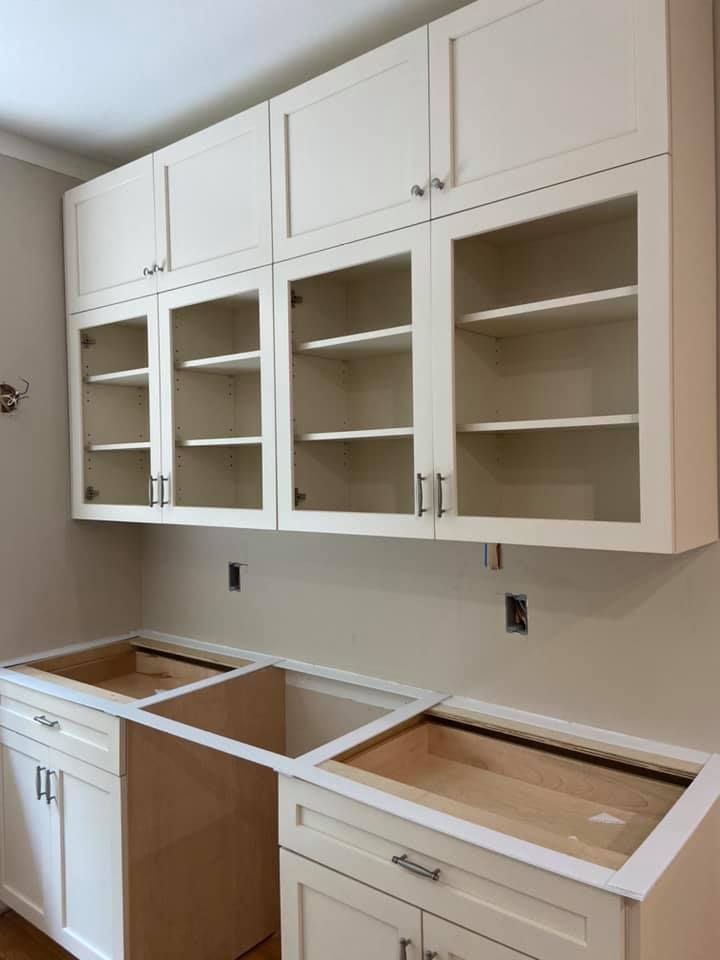 A kitchen with white cabinets and glass doors