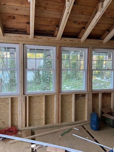 A room under construction with a lot of windows and a wooden ceiling.