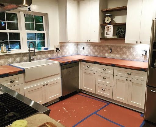 A kitchen with white cabinets , stainless steel appliances , a sink , and a stove.