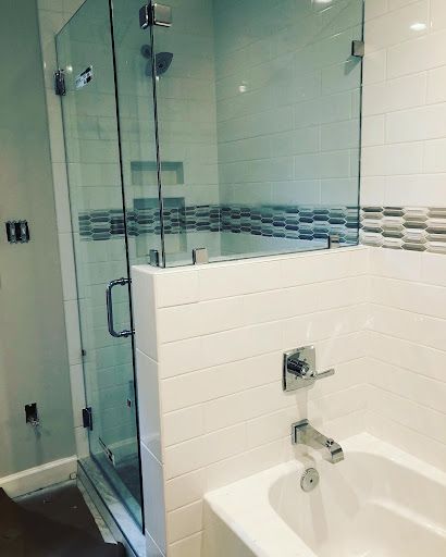 A bathroom with a tub , shower , and glass door.