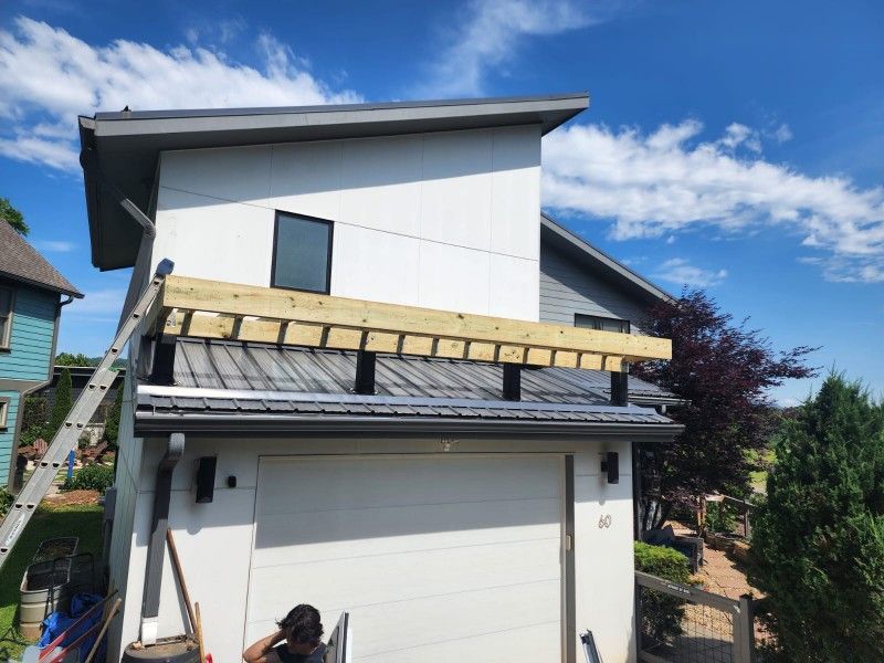 A man is working on the roof of a house.