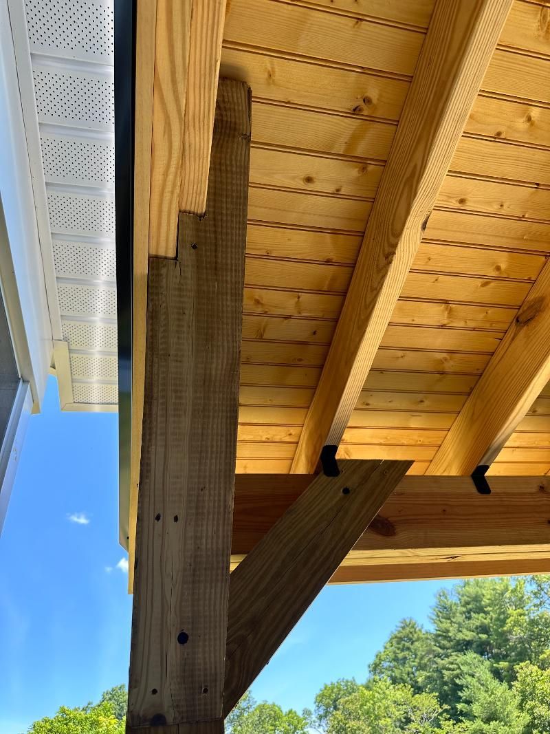 A close up of a wooden roof with a blue sky in the background.