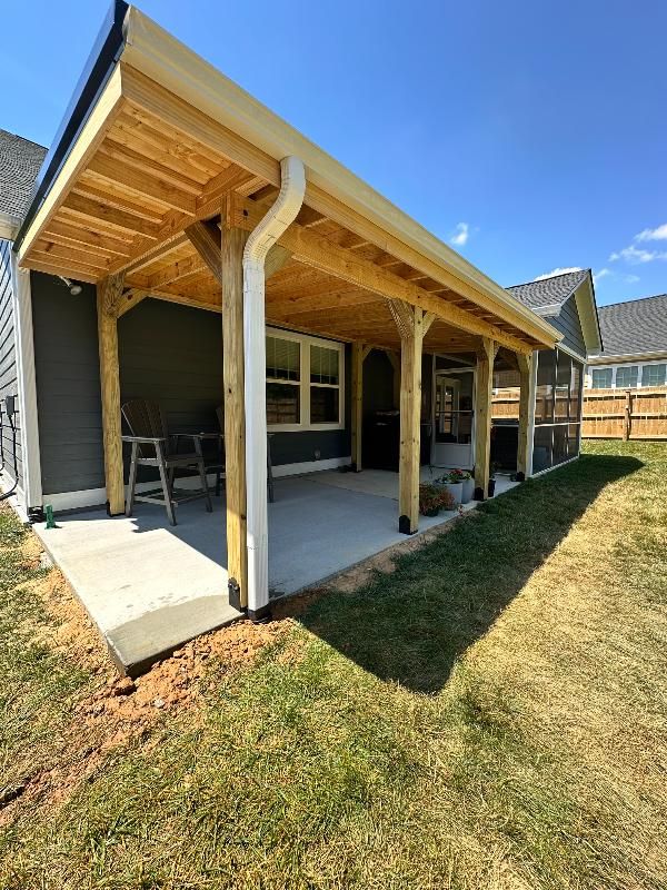 There is a covered patio in the backyard of a house.