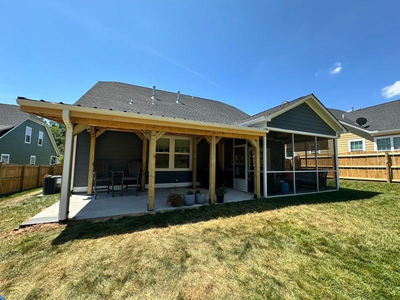 A house with a screened in porch in the backyard.