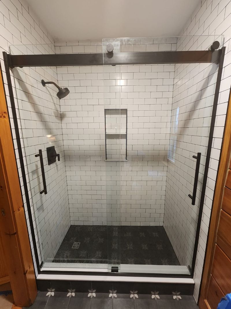 A shower stall with a sliding glass door in a bathroom.