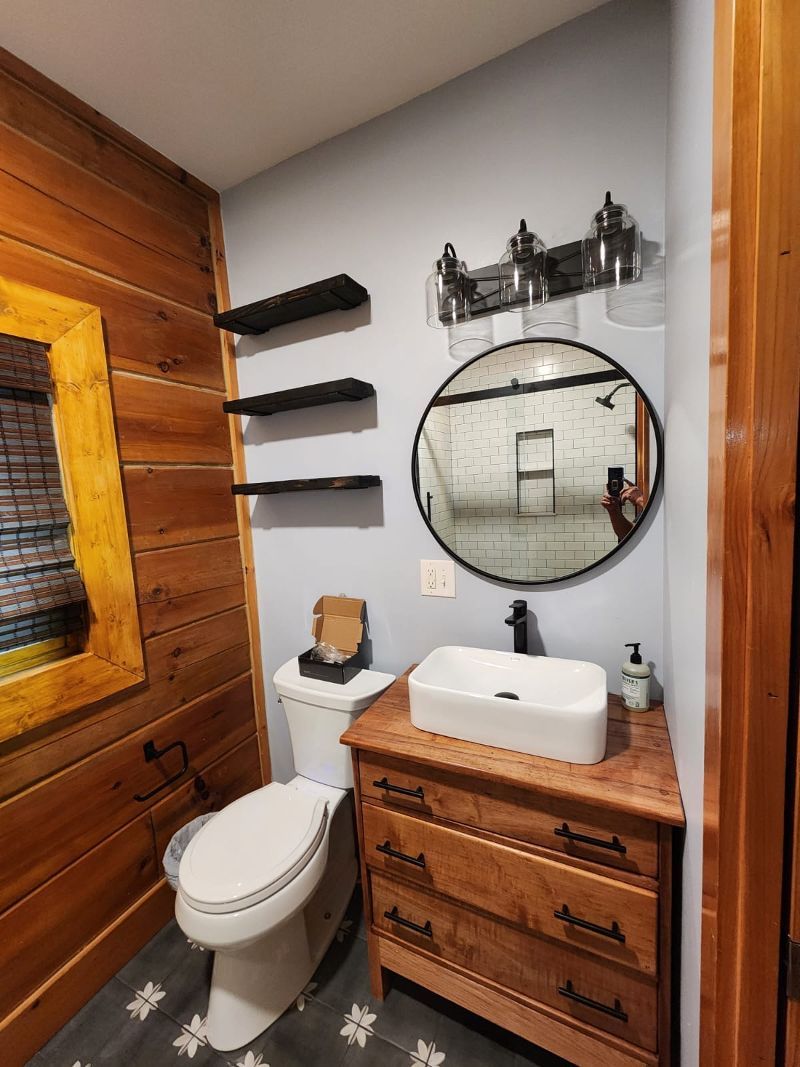 A bathroom with a toilet , sink and mirror.