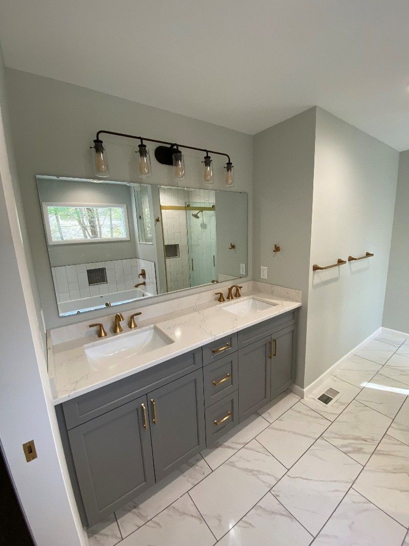 A bathroom with two sinks and a large mirror.