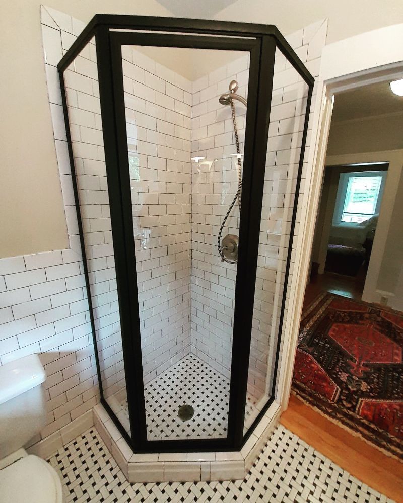 A bathroom with a shower stall and a toilet.