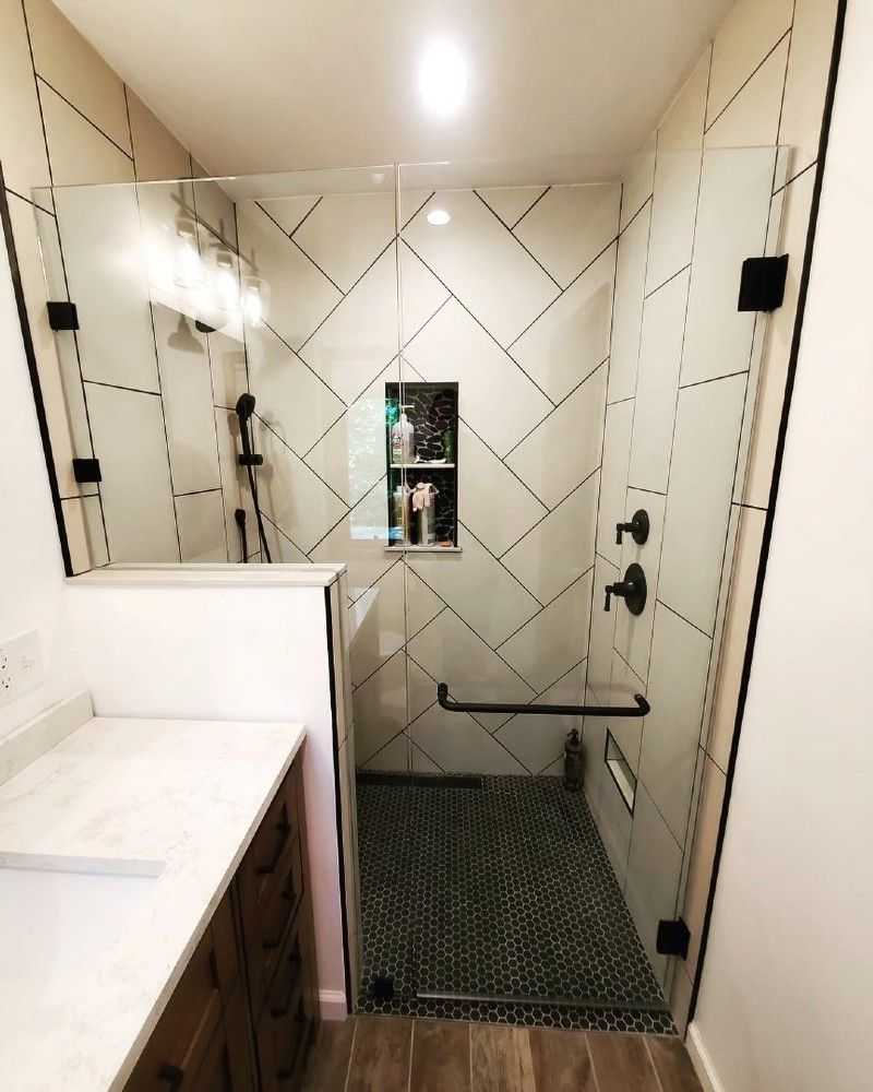 A bathroom with a walk in shower and a sink.