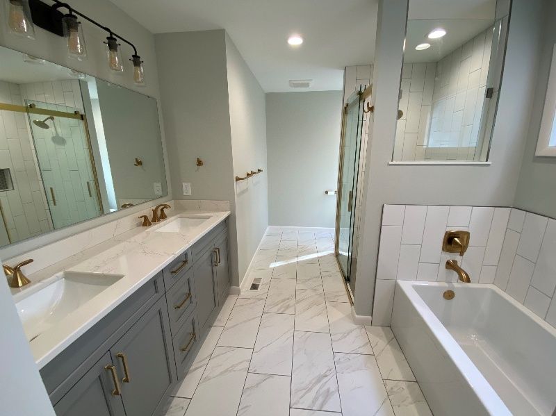A bathroom with two sinks , a tub and a shower.