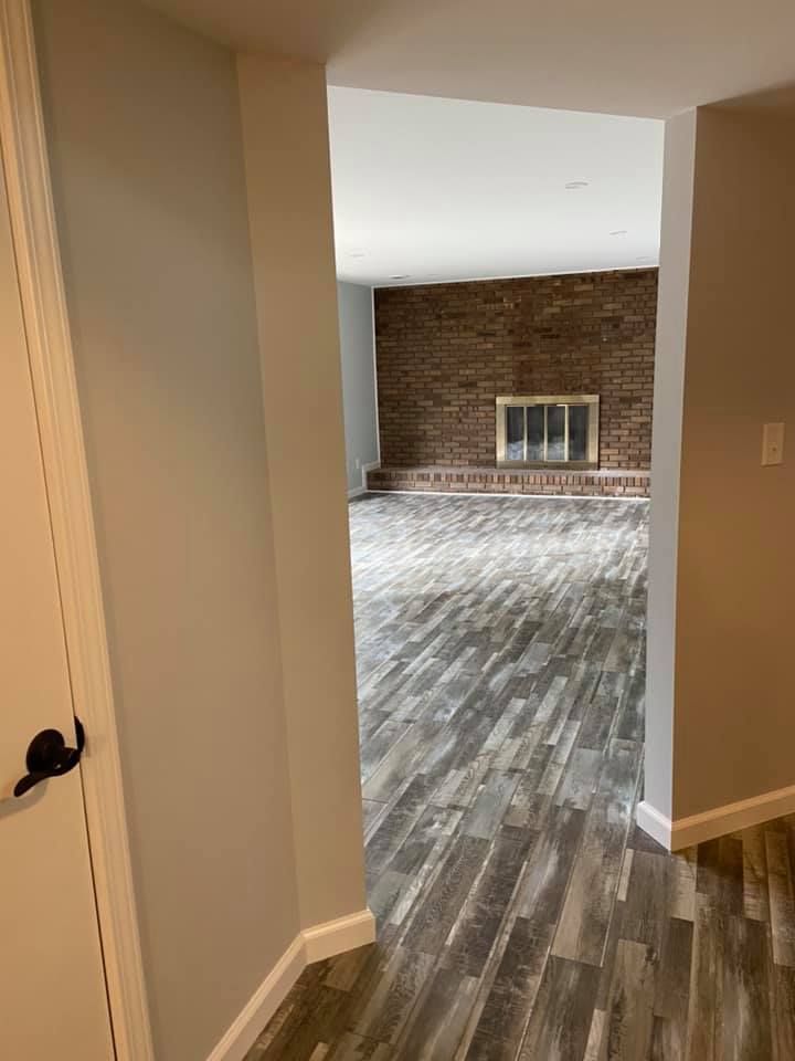 A hallway leading to a living room with a fireplace.