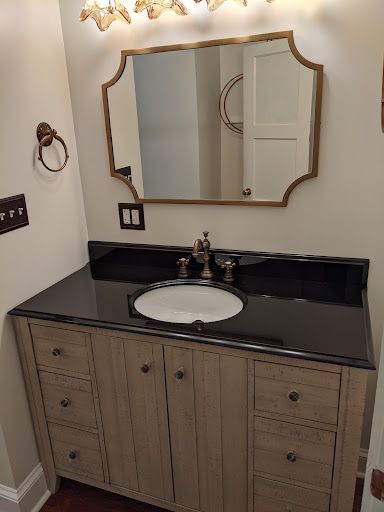 A bathroom with a sink , mirror and drawers.