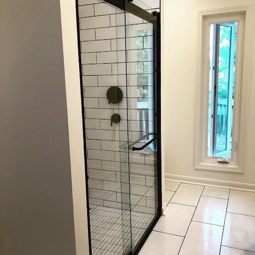 A bathroom with a walk in shower and a window.