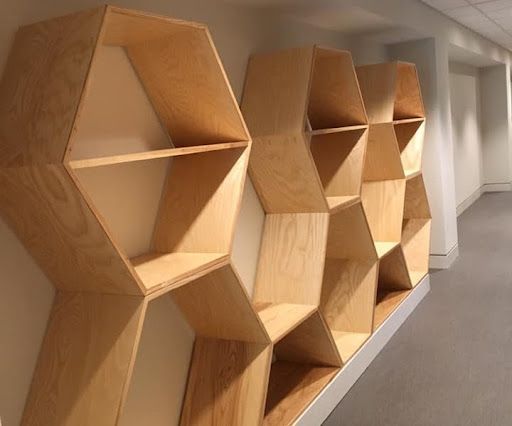 A hallway with a row of wooden shelves shaped like honeycombs.