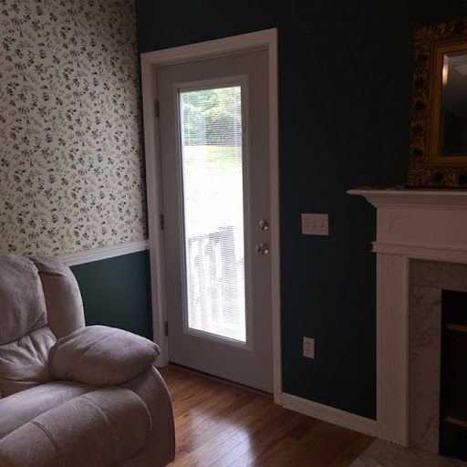 A living room with a chair a fireplace and a door