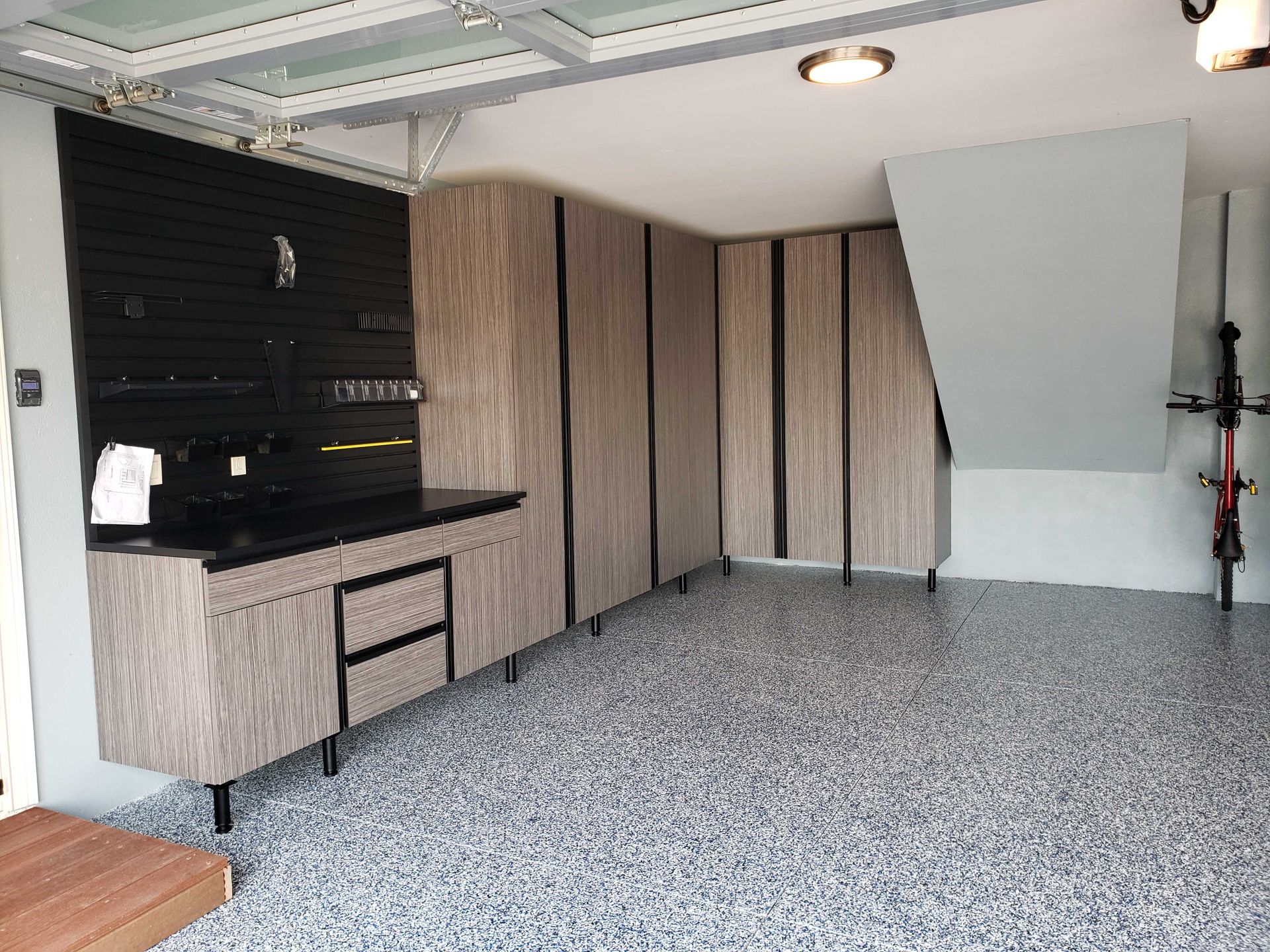 Garage with custom cabinets and epoxy flooring.
