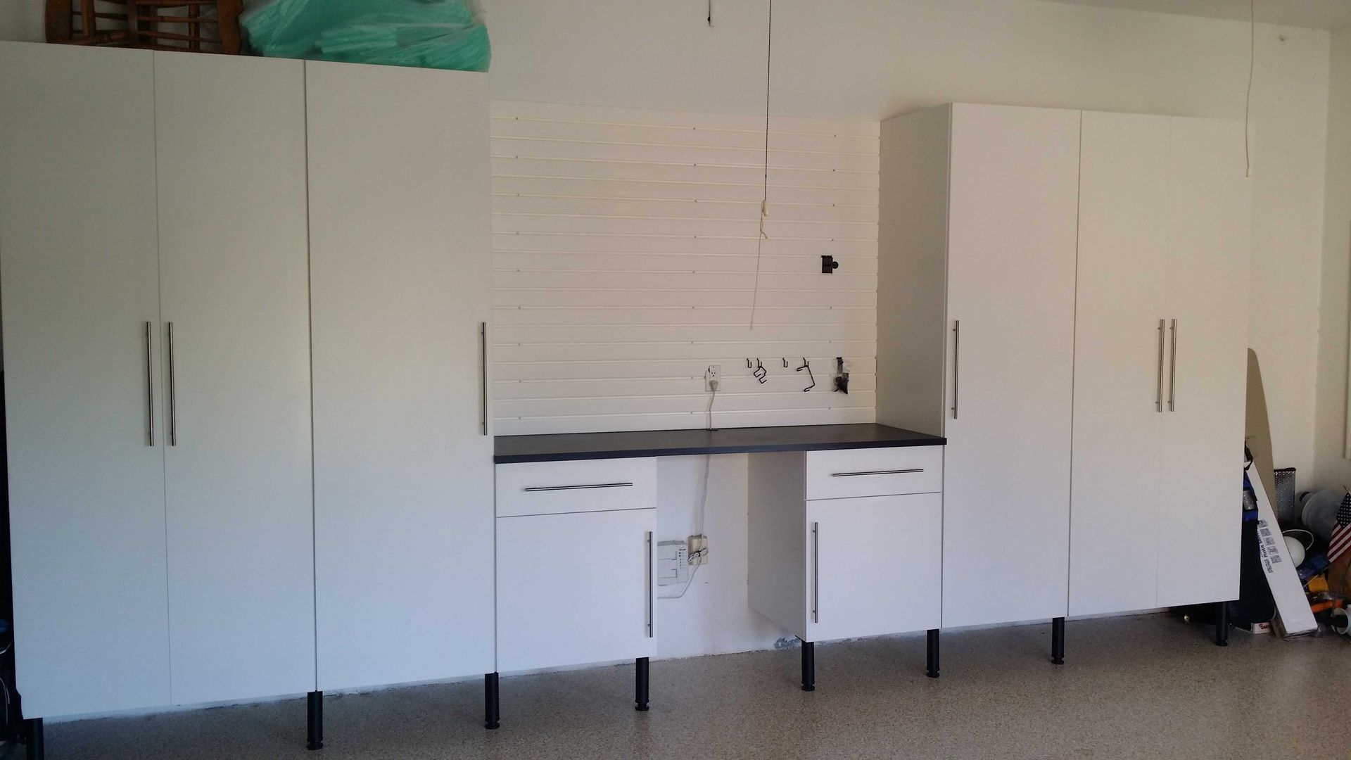 White cabinets and workbench in a garage.