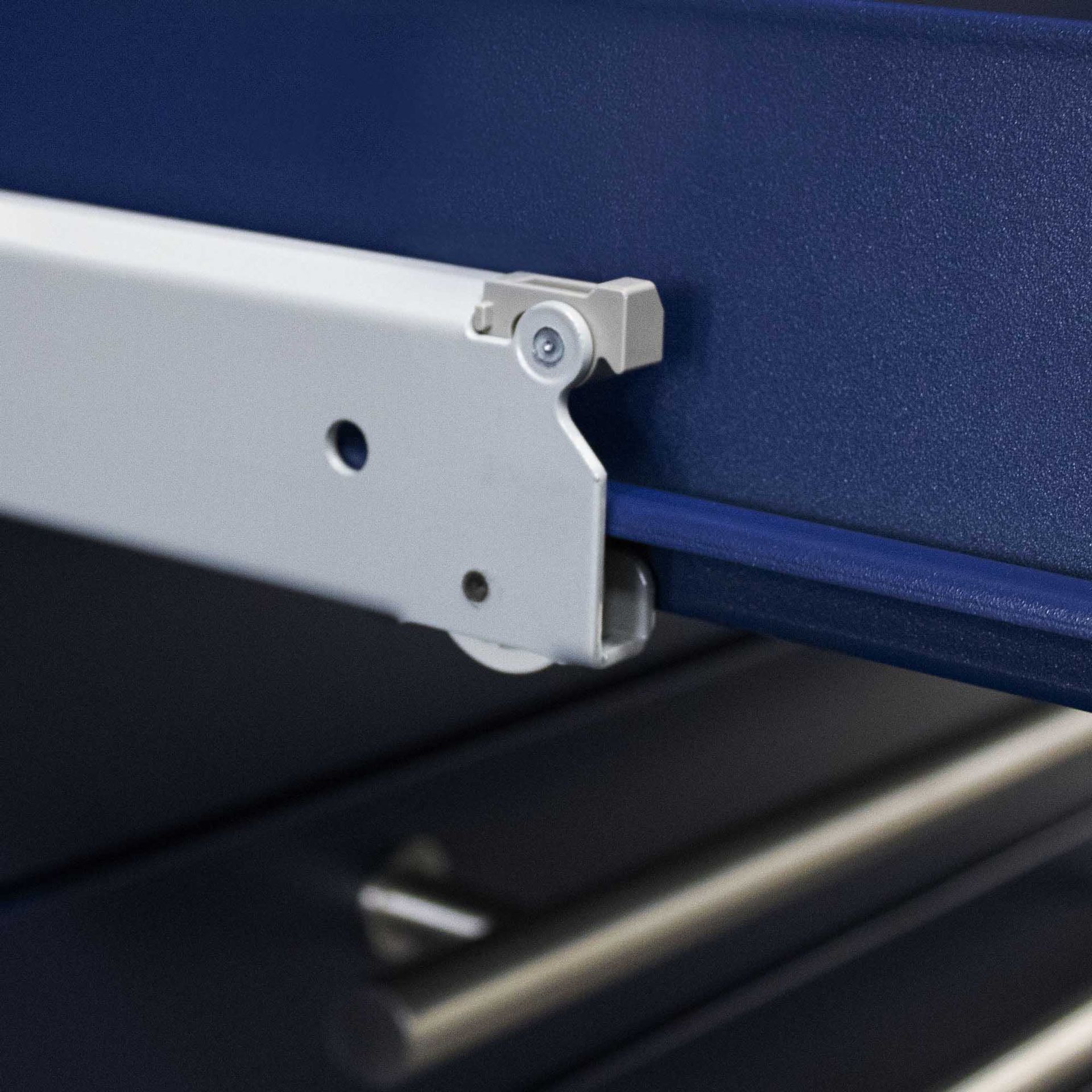 Blue cabinet drawer with a metal track and handle.
