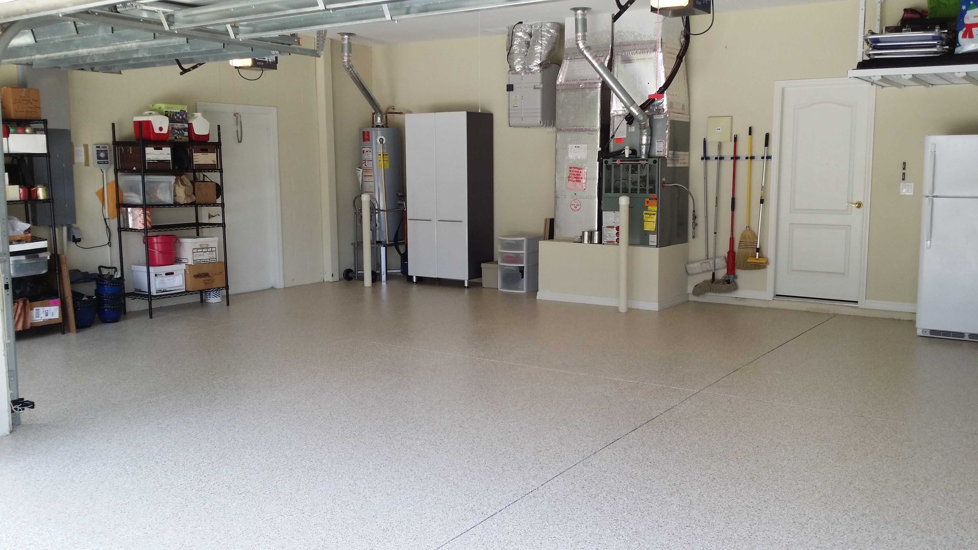 Garage interior with epoxy floor, storage shelves, water heater, and a white refrigerator.