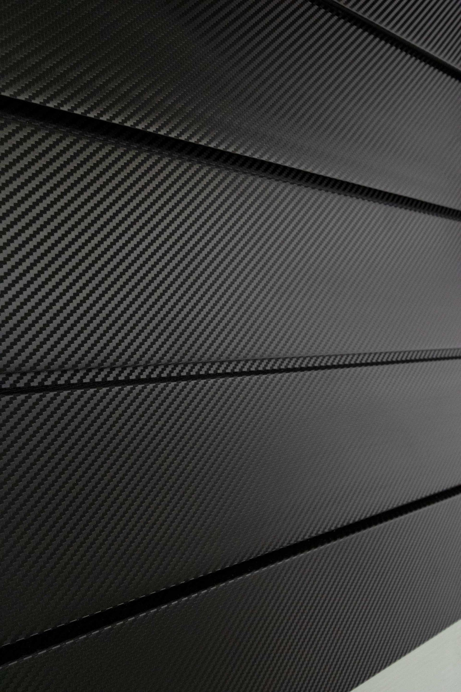 Carbon fiber paneling with a diagonal weave pattern.